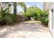 A spacious backyard patio area, surrounded by tropical trees and a wood fence, offers privacy at 1300 Holly Glen Run, Apopka, FL 32703