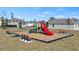 Community playground with slides, wood benches, and mulch bedding at 1323 Blue Ash Ln, Deland, FL 32720