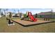 Community playground with colorful slide, benches, and a safety mulch ground covering at 1323 Blue Ash Ln, Deland, FL 32720