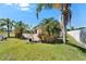 Backyard with grass and tropical landscaping at 2991 Wood Duck Dr, Polk City, FL 33868