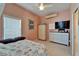 Cozy bedroom with tile floors featuring a queen bed, wardrobe, dresser, and wall-mounted television at 2991 Wood Duck Dr, Polk City, FL 33868