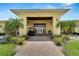 Charming community clubhouse entrance featuring a golf cart, meticulously landscaped greenery, and a brick walkway at 2991 Wood Duck Dr, Polk City, FL 33868