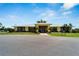 Attractive exterior daytime view of the community clubhouse with palm trees, landscaping, and a paved driveway at 2991 Wood Duck Dr, Polk City, FL 33868