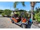 Tan golf cart parked on brick driveway, surrounded by landscaping and palm trees at 2991 Wood Duck Dr, Polk City, FL 33868