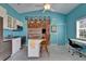 Charming blue kitchen features a kitchen island, stainless steel appliances, and vaulted ceilings at 2991 Wood Duck Dr, Polk City, FL 33868