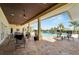 Inviting covered patio seating area with an outdoor ceiling fan, brick floors and views of the community pool at 2991 Wood Duck Dr, Polk City, FL 33868