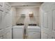Functional laundry room with white washer, dryer, and convenient shelving at 3766 King Hill Dr, Haines City, FL 33844