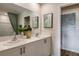 Bright bathroom featuring double sinks, framed art, decor, and a shower with green patterned shower curtain at 3799 King Hill Dr, Haines City, FL 33844