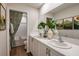 Bathroom features a double sink vanity with white countertops, framed prints and a patterned shower curtain at 3799 King Hill Dr, Haines City, FL 33844