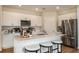 Well-lit kitchen with white cabinets, stainless steel appliances, and a center island with seating at 3799 King Hill Dr, Haines City, FL 33844