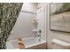 Clean white shower-tub combination features a shower head, shower caddy, shower curtain, and framed print at 3799 King Hill Dr, Haines City, FL 33844