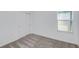 Neutral bedroom with a window providing natural light, plush carpet flooring, and closet at 9084 Wildlight Trl, Wildwood, FL 34785