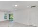 Bright living room with large sliding doors leading to the backyard and a view of lush greenery at 9084 Wildlight Trl, Wildwood, FL 34785