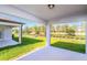 Covered patio with a view of a lush green lawn and foliage at 9084 Wildlight Trl, Wildwood, FL 34785