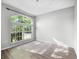 A bright bedroom with laminate wood flooring and a unique, arched window providing ample natural light at 156 Oak Grove Rd, Winter Park, FL 32789