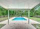 Covered patio with a view of the pool, and a wooded backyard at 2690 Ne 42Nd Pl, Ocala, FL 34479