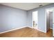 Bedroom featuring wood-look floors, neutral walls, a ceiling fan, and an ensuite bathroom at 2690 Ne 42Nd Pl, Ocala, FL 34479