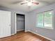 Cozy bedroom showcasing laminate floors, a window view, a ceiling fan, and a closet with sliding doors at 2690 Ne 42Nd Pl, Ocala, FL 34479
