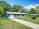 Charming turquoise home with a well-maintained lawn and a long driveway leading to the garage at 2690 Ne 42Nd Pl, Ocala, FL 34479