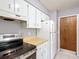 Kitchen with white cabinets, tile flooring, and stainless steel appliances, offering practicality at 2690 Ne 42Nd Pl, Ocala, FL 34479
