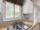 Well-lit kitchen with stainless steel sink, neutral countertops, white cabinets and window view to exterior at 2690 Ne 42Nd Pl, Ocala, FL 34479