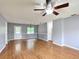 Open-concept living room with laminate floors, fresh paint, a ceiling fan, and direct access to the kitchen at 2690 Ne 42Nd Pl, Ocala, FL 34479