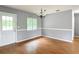 Spacious living room featuring new paint, laminate floors, white trim, a chandelier, and a bright window at 2690 Ne 42Nd Pl, Ocala, FL 34479