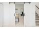View of a bedroom with two beds and an open barn door at 4149 Paragraph Dr, Kissimmee, FL 34746