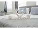 Close up of bed with decorative folded towels and soft, gray blanket at 4149 Paragraph Dr, Kissimmee, FL 34746