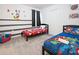 Spacious bedroom featuring multiple beds, themed artwork, and a comfortable carpet at 4149 Paragraph Dr, Kissimmee, FL 34746