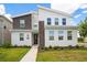 Contemporary two-story home featuring stone accents, a modern design, manicured landscaping, and a welcoming walkway at 4149 Paragraph Dr, Kissimmee, FL 34746