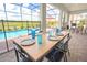 Outdoor dining area with a screened-in patio overlooking a beautiful pool and view at 4149 Paragraph Dr, Kissimmee, FL 34746