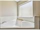Large soaking tub beneath a frosted window at 440 Langham Dr, Davenport, FL 33897