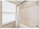 Bathroom featuring a shower-tub combination with white tile and a bright window at 440 Langham Dr, Davenport, FL 33897