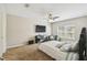 Neutral-toned bedroom with plush carpet, ceiling fan, and large window offering plenty of natural light at 440 Langham Dr, Davenport, FL 33897