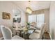 Dining room with a glass table set for six under a stunning chandelier, next to the kitchen at 440 Langham Dr, Davenport, FL 33897