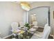 Dining room area showcases an elegant glass table set for six and an arched entrance to the kitchen at 440 Langham Dr, Davenport, FL 33897