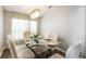 Dining room featuring a glass table set for six with a modern chandelier and neutral decor at 440 Langham Dr, Davenport, FL 33897