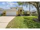 Charming two-story home with a lush lawn and a spacious driveway leading to a two-car garage at 440 Langham Dr, Davenport, FL 33897