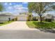 Inviting two-story home featuring a manicured lawn, mature tree, and a spacious driveway at 440 Langham Dr, Davenport, FL 33897
