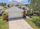 Inviting two-story home with a well-maintained lawn, two-car garage, and a charming facade at 440 Langham Dr, Davenport, FL 33897