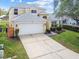 Inviting two-story home with a well-maintained lawn, two-car garage, and a charming facade at 440 Langham Dr, Davenport, FL 33897