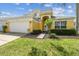 Charming two-story home with a lush lawn and a spacious driveway leading to a two-car garage at 440 Langham Dr, Davenport, FL 33897
