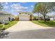 Charming two-story home with a lush lawn and a spacious driveway leading to a two-car garage at 440 Langham Dr, Davenport, FL 33897