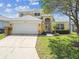 Two-story home boasts well-kept landscaping, attached two-car garage and inviting front entrance at 440 Langham Dr, Davenport, FL 33897