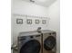 Laundry room featuring modern, stainless steel front-loading washer and dryer with framed art at 440 Langham Dr, Davenport, FL 33897