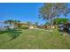 Sprawling backyard featuring lush green grass, mature trees, and a private dock at 6589 Banyan Dr, Indian Lake Estates, FL 33855