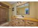 Bright bathroom with wood vanity, tiled floor and walk-in shower at 6589 Banyan Dr, Indian Lake Estates, FL 33855