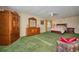 Well-lit bedroom with green carpet, ample closet space and charming furniture at 6589 Banyan Dr, Indian Lake Estates, FL 33855