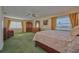 Spacious bedroom features plush green carpet, ceiling fan and large windows with natural light at 6589 Banyan Dr, Indian Lake Estates, FL 33855